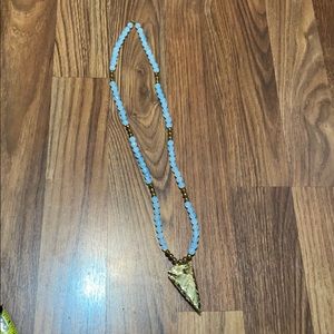 Long blue and gold arrow necklace.